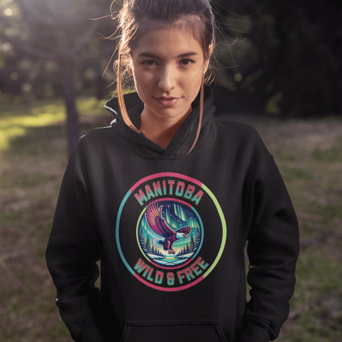 Soar high in our Manitoba – Wild & Free hoodie, featuring a bold flying bald eagle beneath the captivating northern lights.